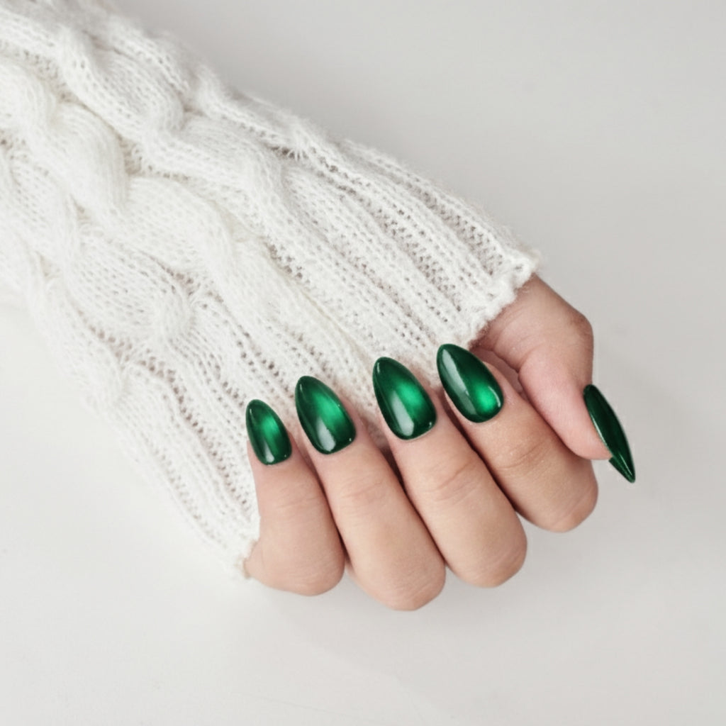 Short almond-shaped emerald green press-on nails by Nailique, reusable dark green gel tips with glue and remover for salon-quality manicures.