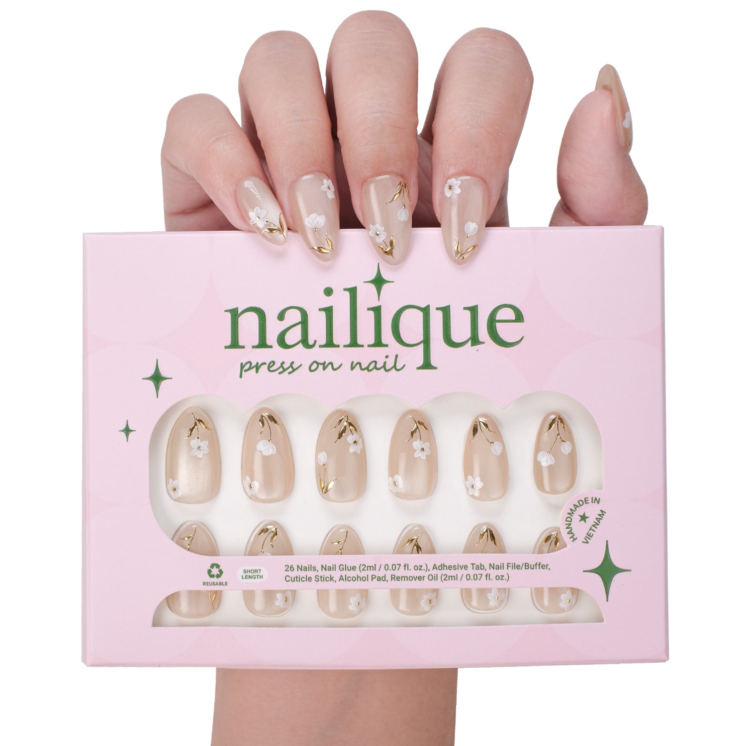 Short almond press-on nails by nailique with white floral design, gold foil accents, reusable tips, and lamp-curable glue.