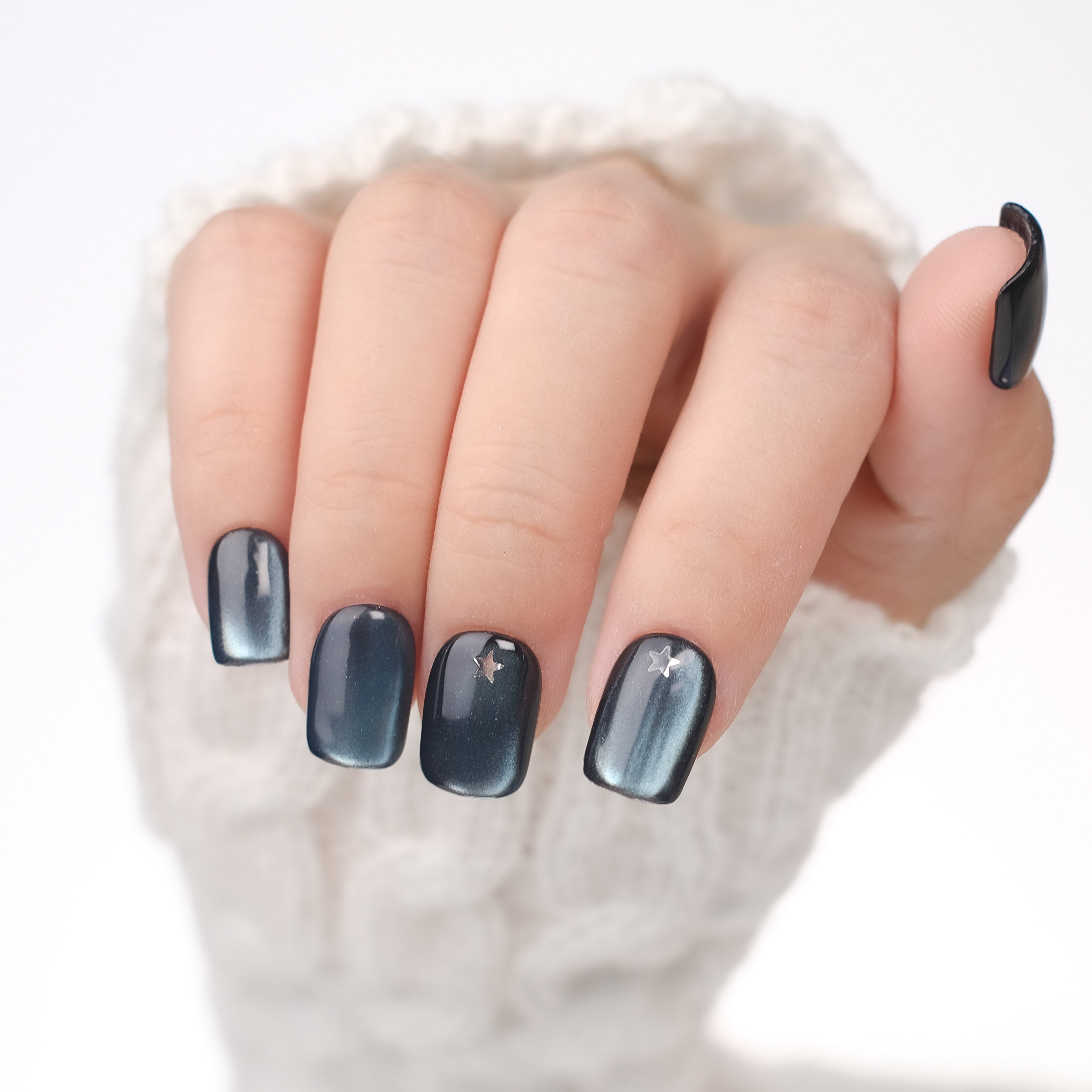 Handmade short square blue cat eye gel press on nails with silver star design, reusable tips, and lamp-curable glue by Nailique.