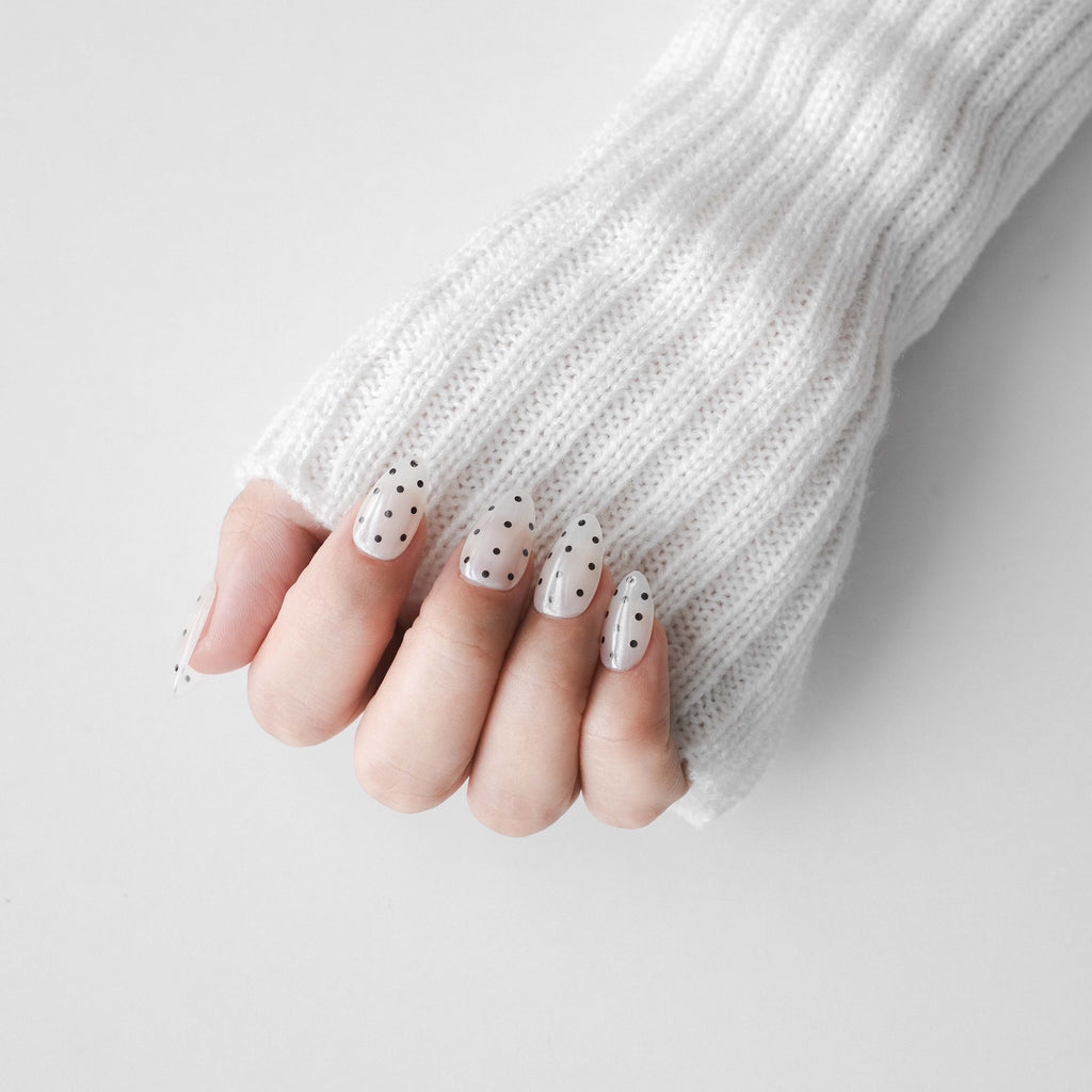 Short almond press-on nails by Nailique featuring chrome glaze with white and black polka dot design, handmade soft gel manicure
