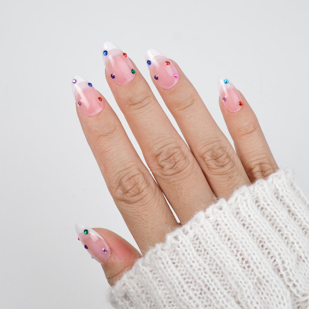 Nailique short almond press-on nails with nude base, white French tips, colorful rhinestones, and sparkle soft gel finish, 26 reusable pieces.