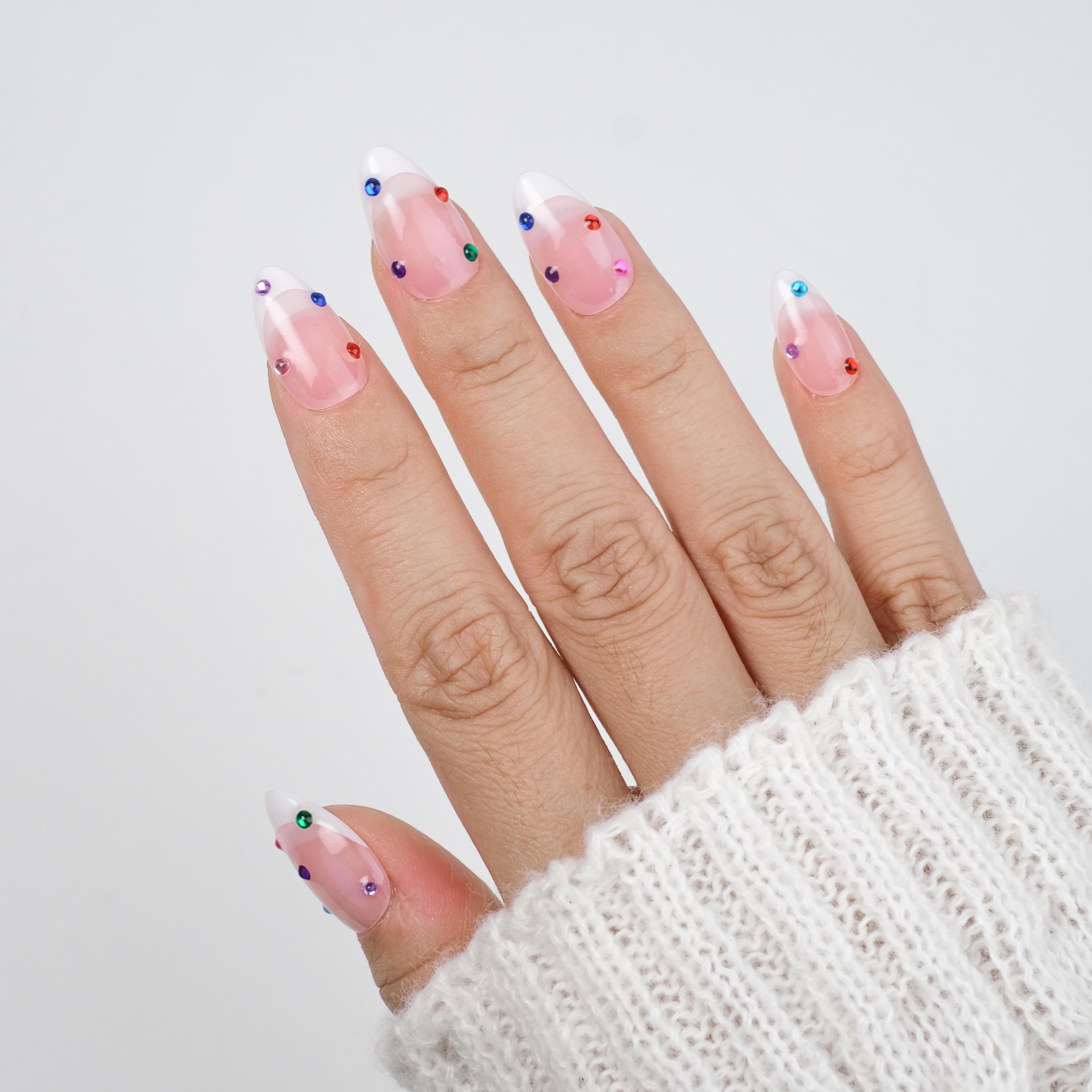 Nailique short almond press-on nails with nude base, white French tips, colorful rhinestones, and sparkle soft gel finish, 26 reusable pieces.