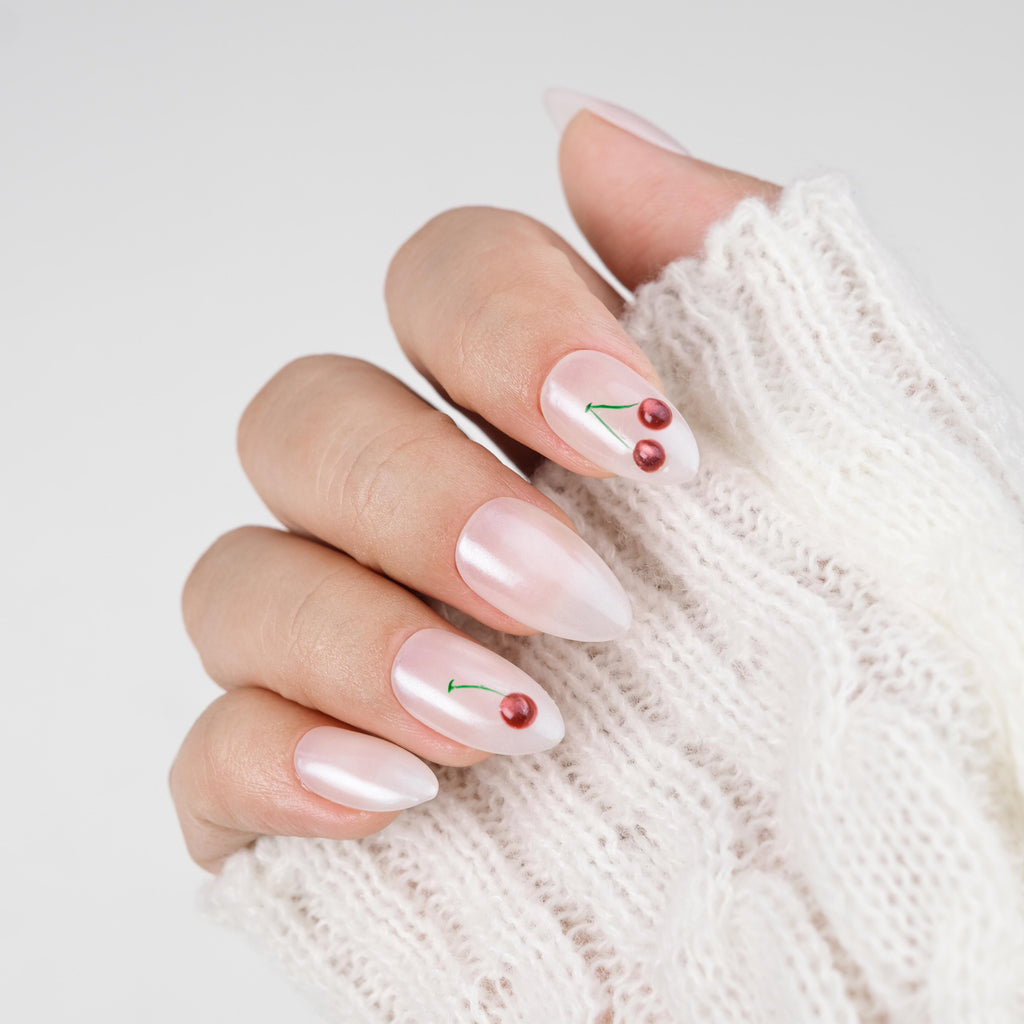 Handmade short almond press on nails by Nailique with 3D cherry design, soft gel, milky pearl finish, reusable with glue and remover.
