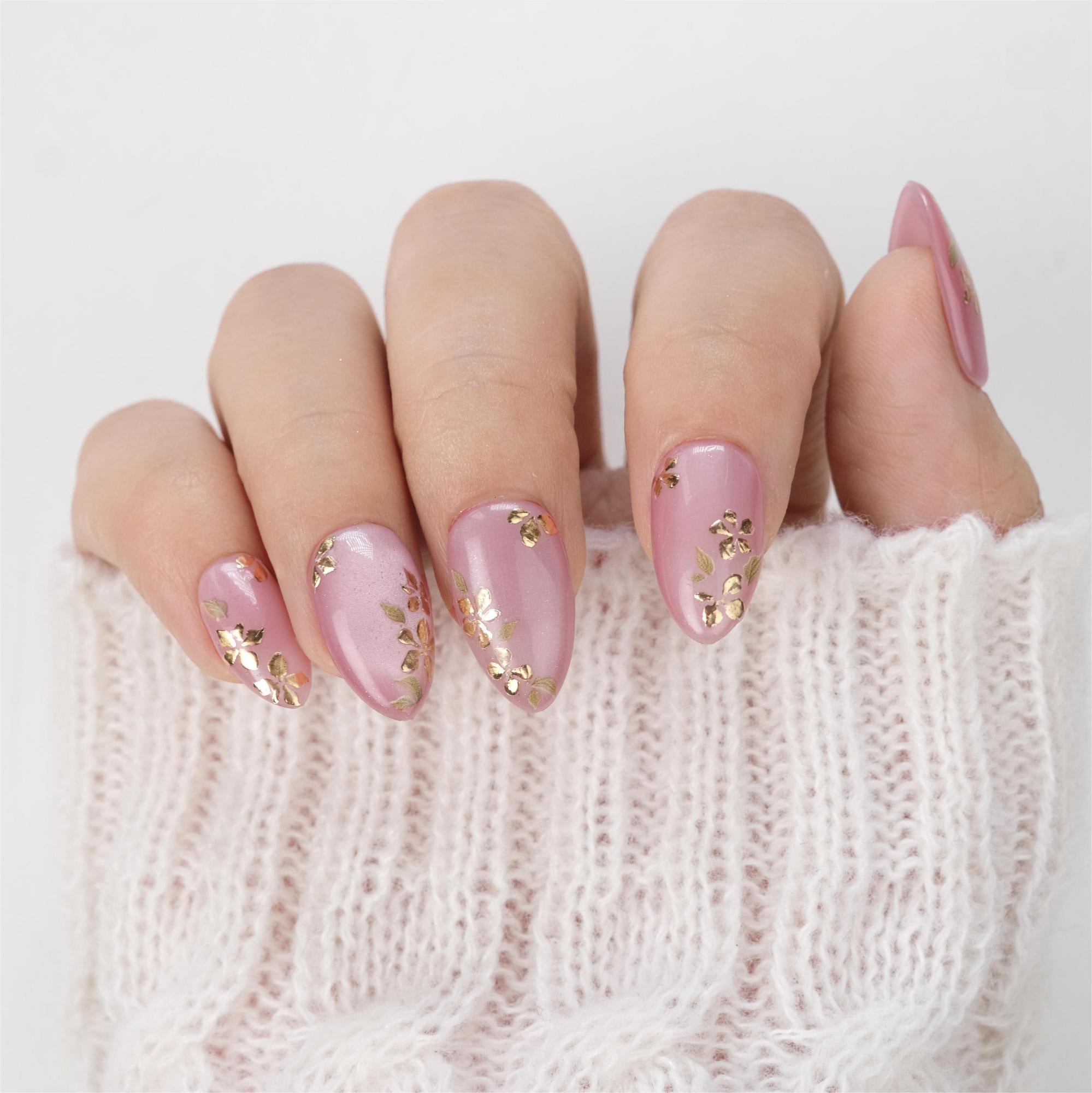 Short almond press-on nails by nailique featuring pink cat eye gel with gold foil floral design, reusable with glue and remover.