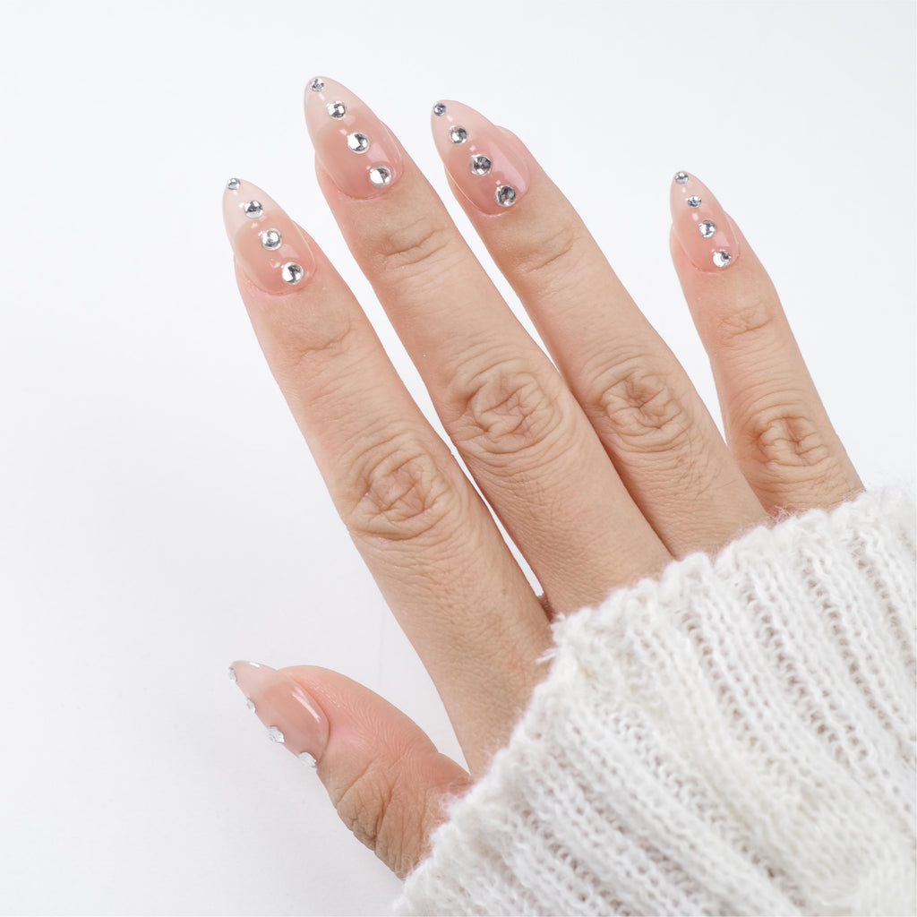 Nude short almond press-on nails by Nailique with silver crystal rhinestones, minimal sparkle, handmade soft gel, reusable 26-piece set