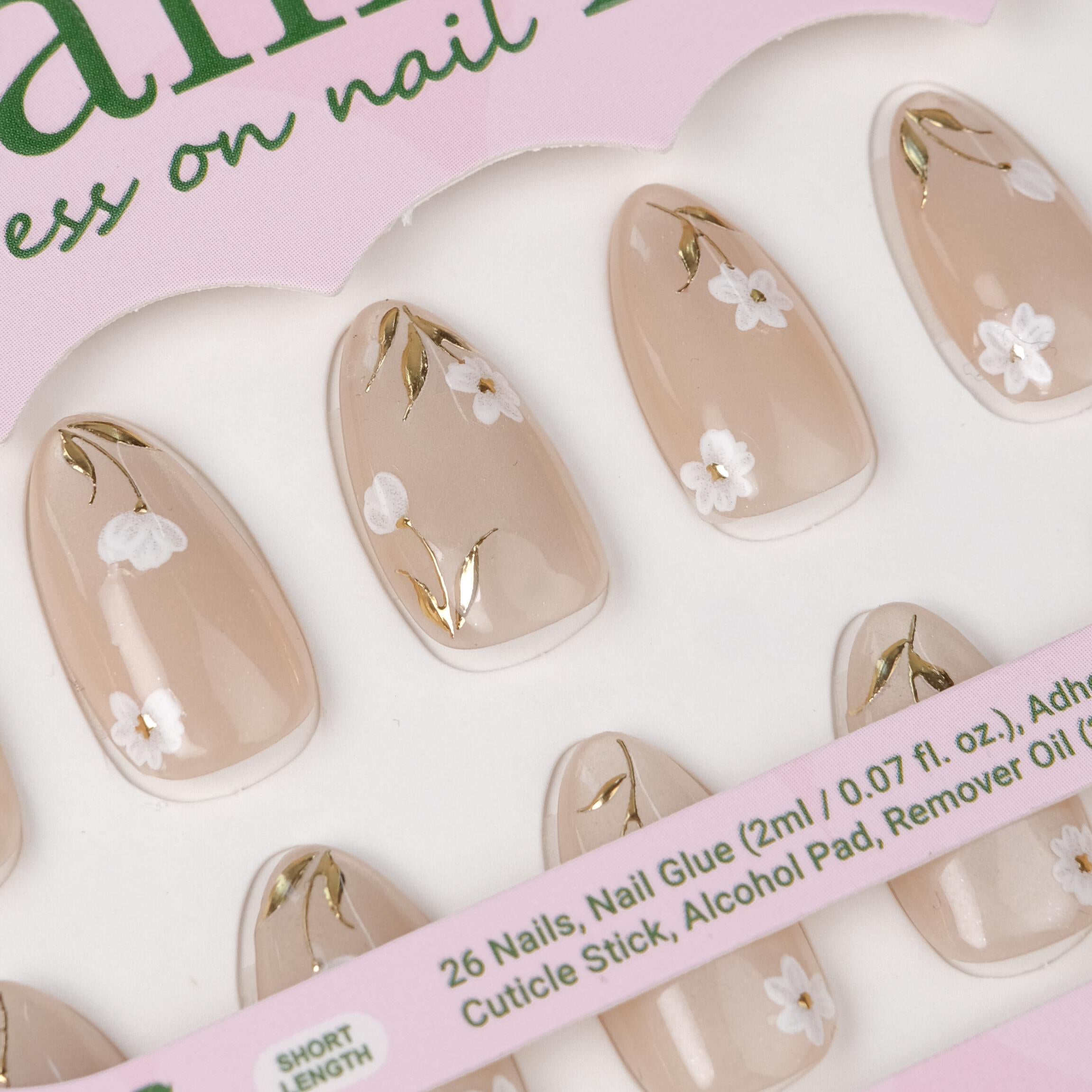 Handmade white floral almond-shaped press on nails with gold foil accents, includes 26 reusable tips and lamp-curable glue by Nailique.