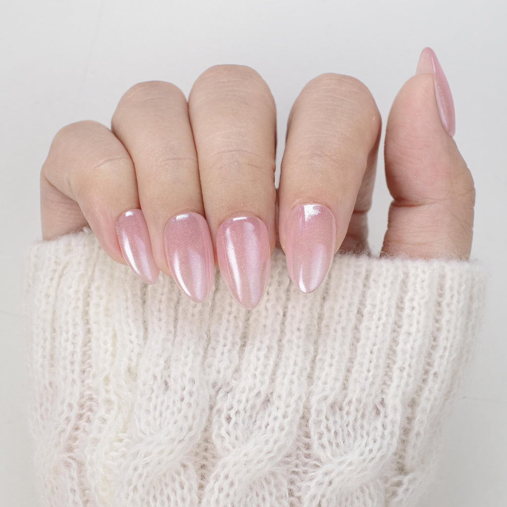 Short almond press-on nails by Nailique with baby pink chrome finish, glitter shimmer, 26 reusable tips, and lamp-curable glue.
