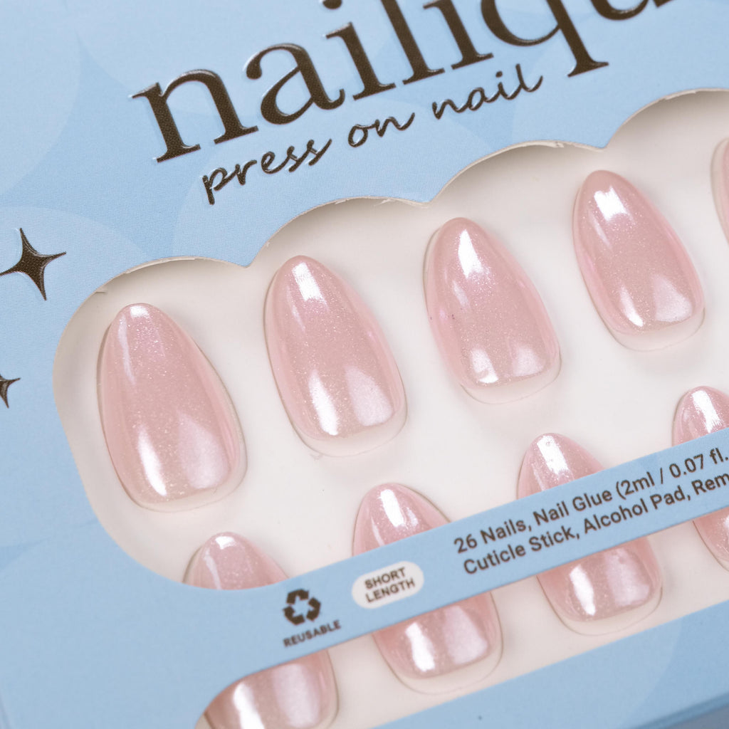 Short almond press-on nails by Nailique with baby pink chrome glaze, glitter shimmer, reusable tips, and lamp-curable glue for a chic manicure.