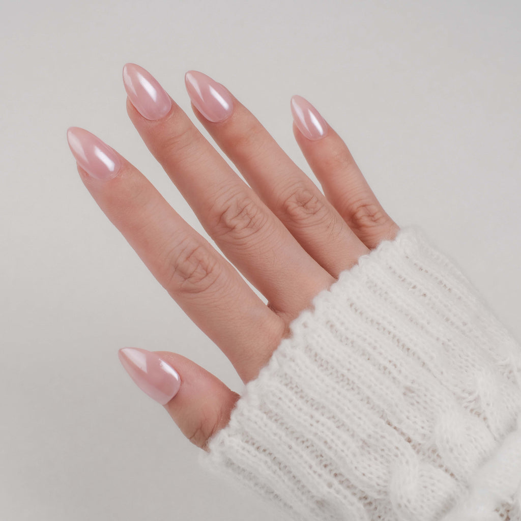 Handmade short almond press-on nails by Nailique with chrome glaze, donut design, soft gel, ombre nude pink finish.