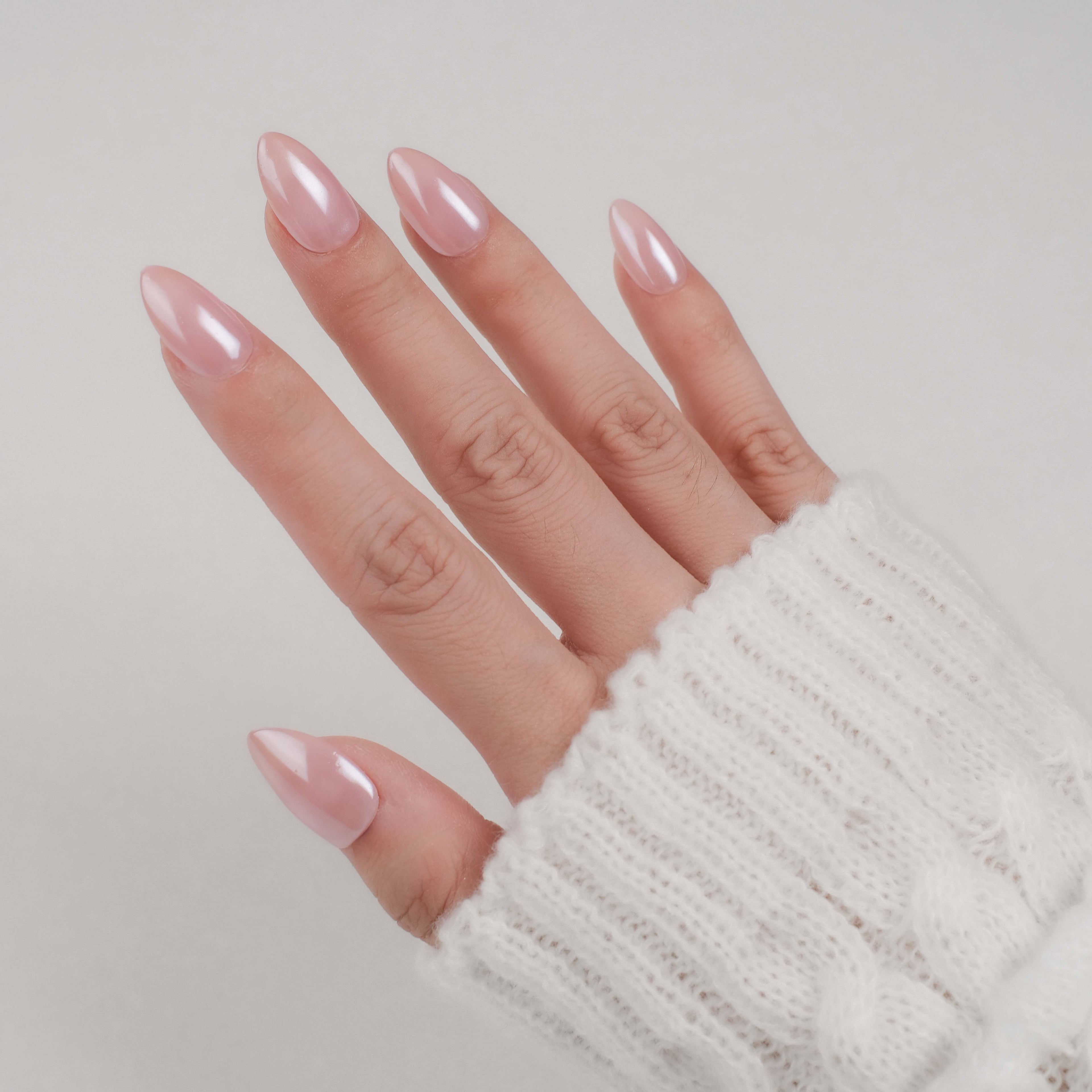 Handmade short almond press-on nails by Nailique with chrome glaze, donut design, soft gel, ombre nude pink finish.