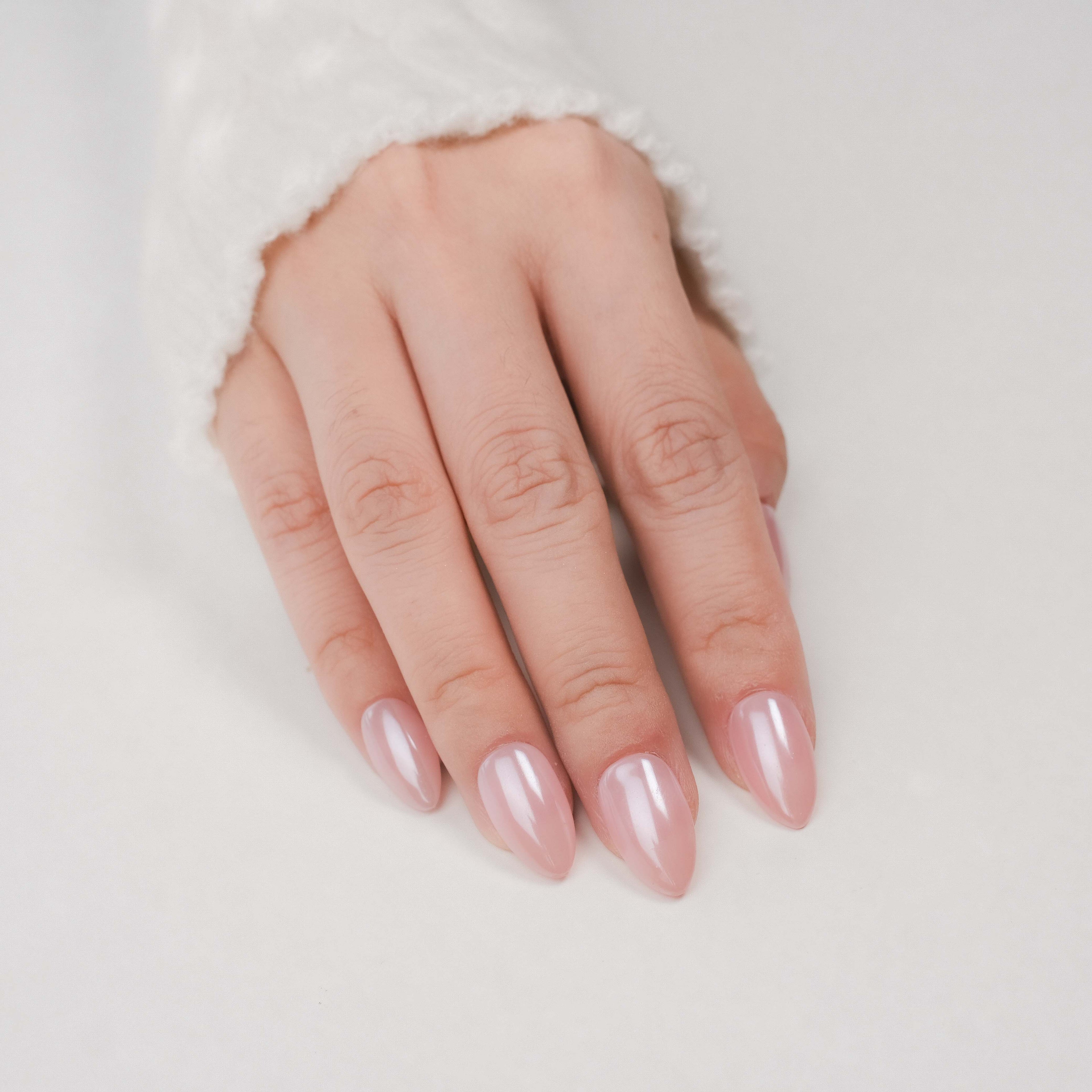 Handmade short almond press on nails by Nailique with chrome glazed donut design and ombre nude pink soft gel finish.