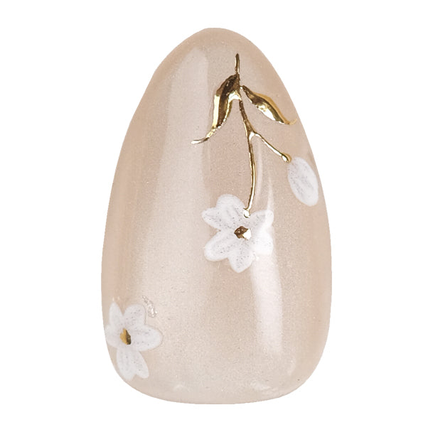 Short almond press-on nails by Nailique with white floral design, gold foil accents, reusable tips, and lamp-curable glue.