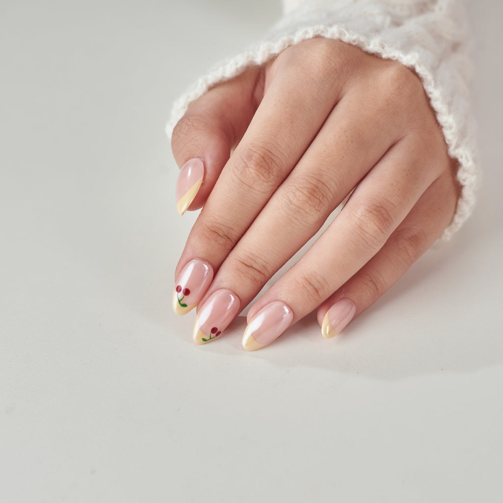 Short almond-shaped handmade press on nails by nailique with butter yellow base, cherry glazed chrome French tips, soft gel finish.