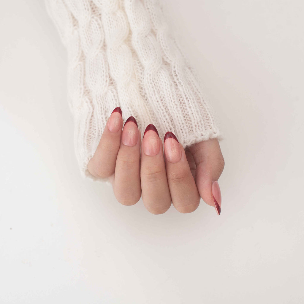 Short almond press on nails by Nailique featuring handmade red French tips, cat eye soft gel with yellow shimmer design.