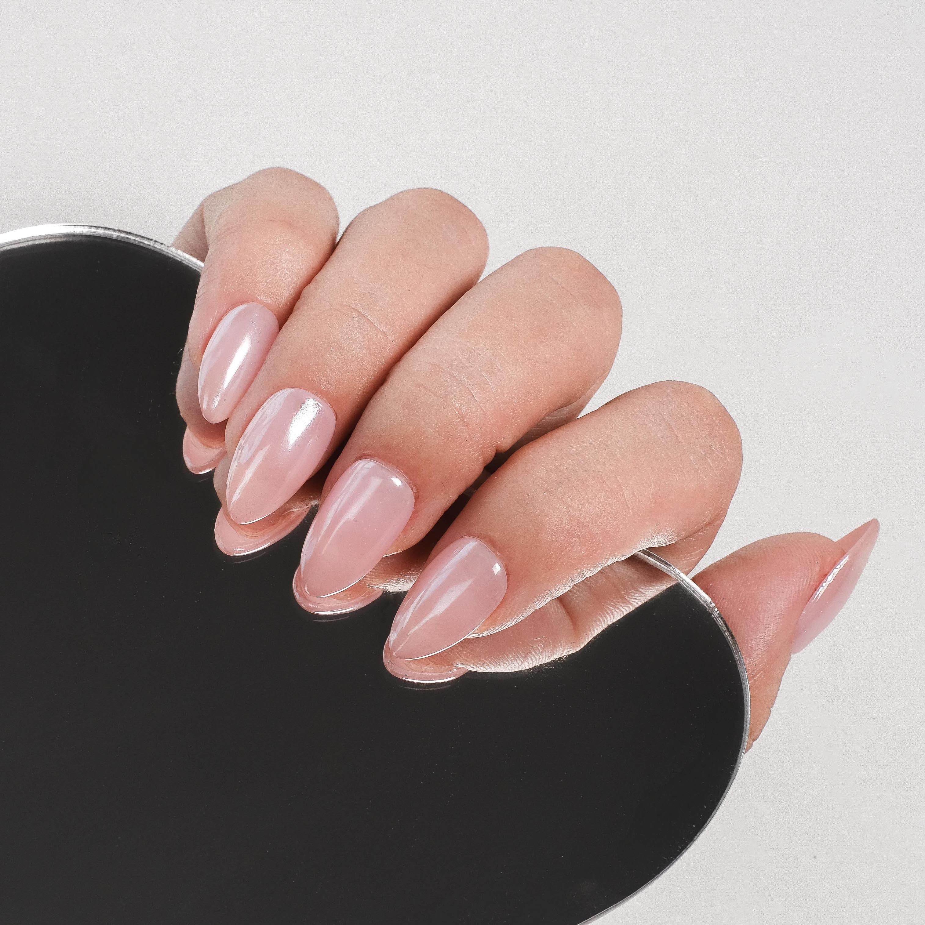 Handmade short almond press-on nails by Nailique with chrome glazed donut design and soft gel ombre nude pink finish.